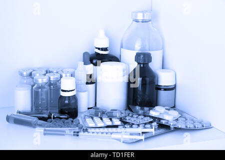 Medizinische Flaschen und Pillen in blaues Licht Stockfoto