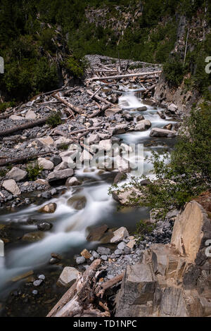 Einen seichten Fluss am Rande eines Nationalparks in den USA, mit langer Belichtungszeit Bewegungsunschärfe im Wasser zu schaffen, da es über Felsen und Bäume Kaskaden, niemand im Bild Stockfoto