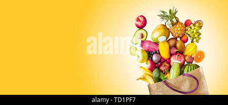 Bunte gelb panorama Banner mit Kopie Raum ein großes Sortiment an frischen tropischen Früchten und Säften, die reich an Vitaminen Verschütten von einem wiederverwendbaren gro Stockfoto