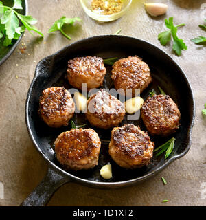 Nahaufnahme von Hackfleisch Schnitzel in der Pfanne über braunen Hintergrund. Stockfoto