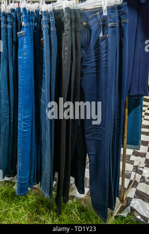Kleidung hängen auf einem Regal zu einem Nachtmarkt in Thailand Stockfoto