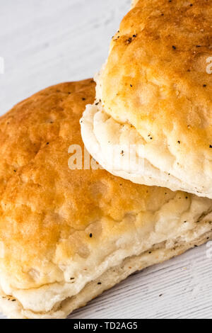 Knusprige Brötchen auf einem Holzbrett und bereit, gerade aus der ovan zu essen. Ein gutes Bild für einen Bäcker oder Ähnliches. Stockfoto
