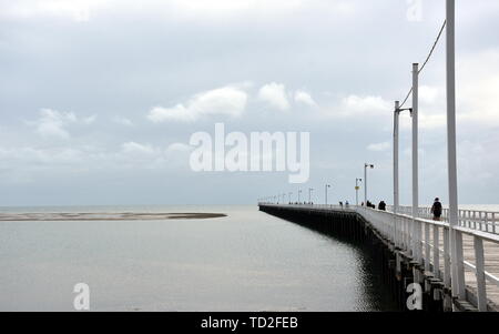 Tolle Aussicht von Hervey Bay aus der Holz- Urangan Pier. Der Pier ist auch ein beliebter Angelplatz bei allen Gezeiten. Sprudeln Meer an einem bewölkten Tag. Horizontale Stockfoto