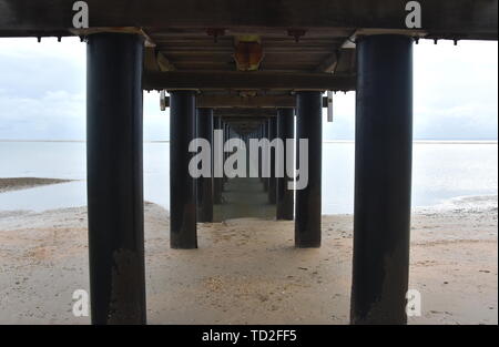 Unter Urangan Pier Perspektive betrachten. Unter einem Pier in Hervey Bay (Queensland, Australien), zeigt die Struktur der Pfähle und Support. Stockfoto