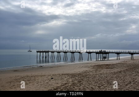 Tolle Aussicht von Hervey Bay aus der Holz- Torquay Jetty. Der Pier ist auch ein beliebter Angelplatz bei allen Gezeiten. Sprudeln Meer an einem bewölkten Tag. Horizontale Stockfoto