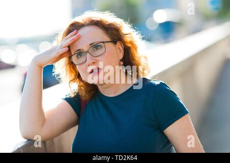 Attraktive Frau auf der Straße das Gefühl plötzlich Kopfschmerzen - Unbehagen Geste Stockfoto