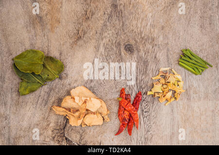 Zutaten für populäre thailändische Suppe Tom - Yum Kung. Kalk, Galgant, roter Chili, Cherry Tomaten, Zitronengras und Kaffernlimette Blatt auf dem Schwarzen Brett. Flach Stockfoto