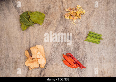 Zutaten für populäre thailändische Suppe Tom - Yum Kung. Kalk, Galgant, roter Chili, Cherry Tomaten, Zitronengras und Kaffernlimette Blatt auf dem Schwarzen Brett. Flach Stockfoto