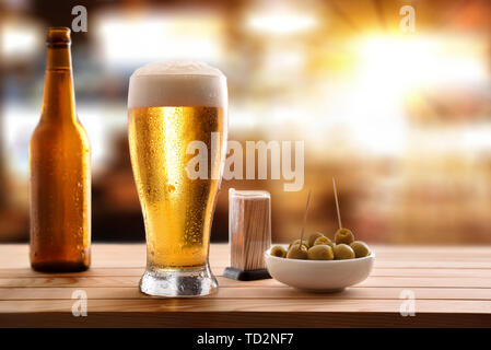 Vorspeise mit Glas frisches Bier auf hölzernen Lattenrost Tabelle im Pub. Horizontale Komposition. Vorderansicht. Stockfoto