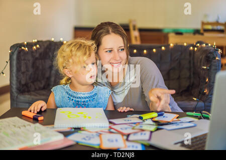 Ein Lehrer, ein Tutor für heimunterricht und ein Lehrer am Tisch. Oder Mutter und Tochter. Homeschooling Stockfoto