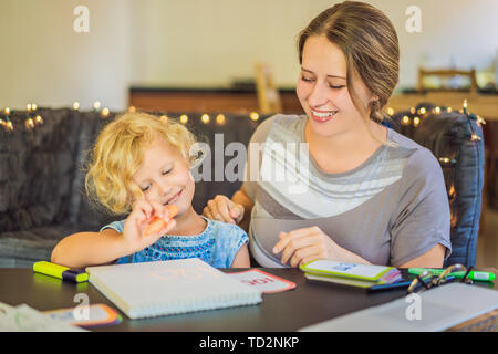 Ein Lehrer, ein Tutor für heimunterricht und ein Lehrer am Tisch. Oder Mutter und Tochter. Homeschooling Stockfoto