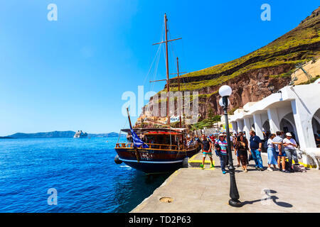 Santorini, Griechenland - 26. April 2019: Menschen und alten Segelschiff im Alten Hafen von Fira Stockfoto