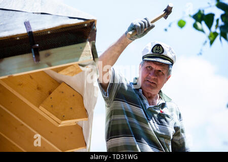 Tischler Arbeiten auf dem Dach Holzkonstruktion - das Fahren in den großen Nagel Stockfoto