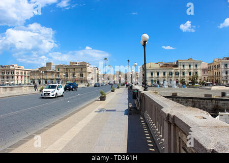 Syrakus, Sizilien, Italien - Apr 10 2019: Brücke zwischen Syrakus und die berühmte Insel Ortygia fotografiert an einem sonnigen Tag mit Auto. Schöne Ortigia ist ein beliebter Ort für Touristen. Stockfoto