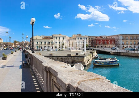 Syrakus, Sizilien, Italien - Apr 10 2019: schönen kleinen Hafen mit den Booten auf das Meer zwischen Syrakus und Ortigia Insel von der Brücke, die die beiden Teile der historischen Stadt fotografiert. Beliebter Ort. Stockfoto