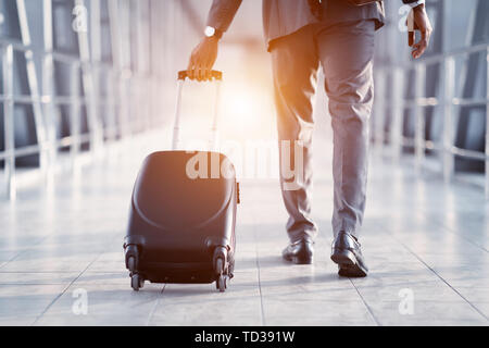Geschäftsmann mit Koffer, Wandern über Fluggastbrücken Stockfoto