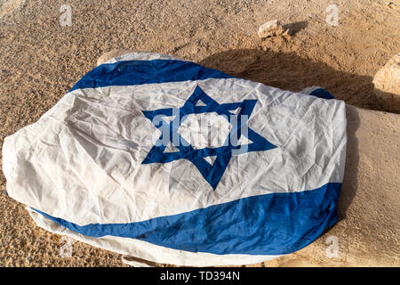 In der Nähe von Weißen und Blauen Flagge mit David Stern links auf dem Boden im trockenen Ort. Symbol der verheißenen Land. Patriotische Gefühle. Schutz von Israel Stockfoto