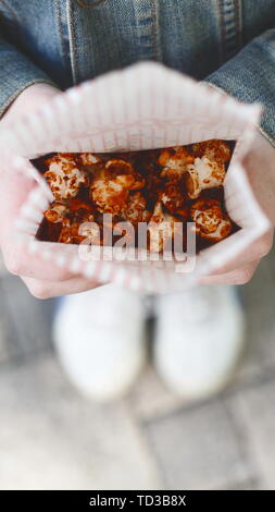 Draufsicht auf das Kind mit Popcorn in Händen outdoor Stockfoto