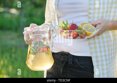 Frühling Sommer Erfrischungen, Frau in Natur Holding jar der Erdbeere Minze und Zitrone. Stockfoto