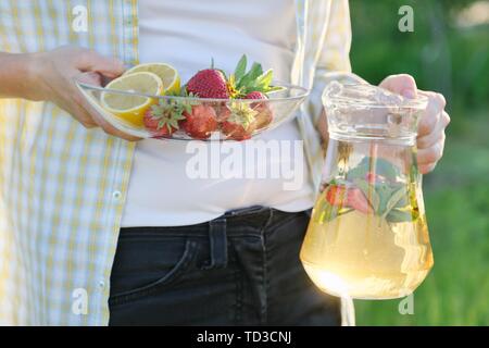 Frühling Sommer Erfrischungen, Frau in Natur Holding jar der Erdbeere Minze und Zitrone. Stockfoto
