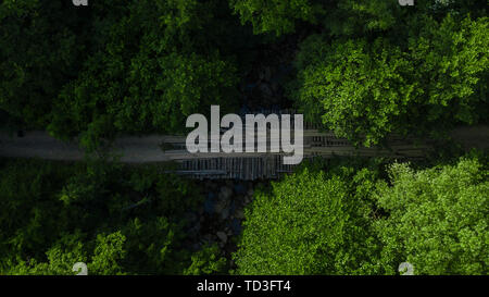Luftaufnahme von alten, verlassenen Brücke in einem dichten grünen Wald Stockfoto