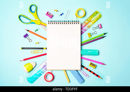 Zurück Hintergrund mit Notepad zu Schule, bunte Stifte, Lineal, Schere, Clips auf Pastell-blaue Hintergrund. Stockfoto