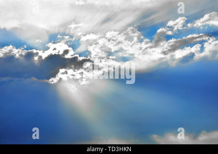 Schönen Himmel mit Strahlen der Sonne hinter einem Cumulus cloud ausgeblendet Stockfoto