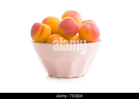 Süße Aprikosen Früchte in der Schüssel auf weißem Hintergrund. Stockfoto