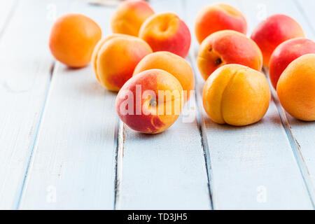 Süße Aprikosen Früchte auf Blau Holztisch. Stockfoto