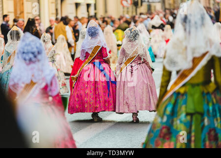 Valencia, Spanien - 17. März 2019: Fallera Kommission paradieren Calle de la Paz, von hinten gesehen, während der Fallas bietet. Stockfoto