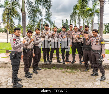 Makassar, Sulawesi, Indonesien - 28. Februar 2019: Nahaufnahme der Gruppe von starken Polizisten der Abteilung Sabhara mit Palmen in zurück. Stockfoto