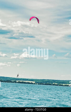 Ein kiteboarder ist über Wasser durch einen power Kite gezogen Stockfoto