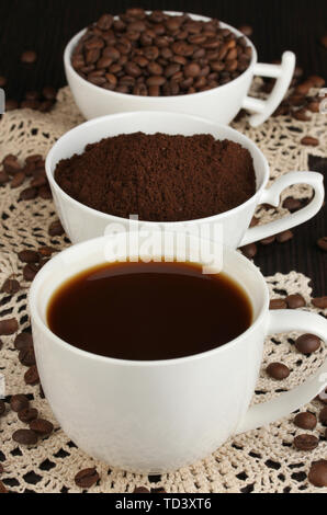 Verschiedene Arten von Kaffee in drei Tassen auf hölzernen Tisch Stockfoto