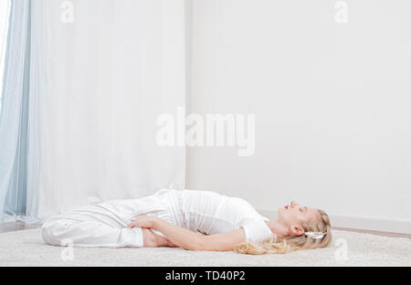 Yoga Zeit. Schöne Frau ist Yoga zu Hause, Mädchen tun Supta Virasanaexercise darstellen Stockfoto