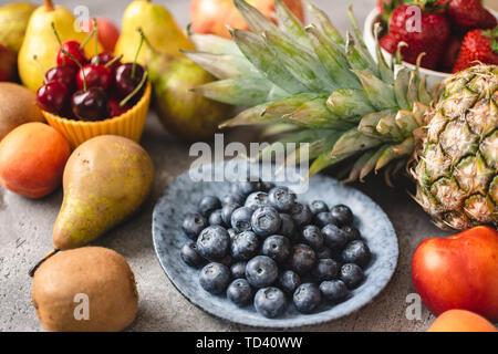Bio Heidelbeeren und frische Früchte. Vegetarische Ernährung und gesunde Ernährung Konzept. Stockfoto