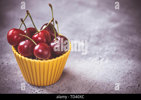 Frische rote Bio Kirschen in Gelb Schüssel als Sommer Konzept Stockfoto