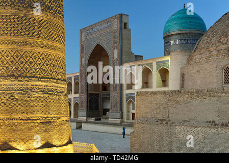 Der Tourist macht das Foto auf dem Hauptplatz in Buchara, wo ist Mir-i-arabischen Medressa und Kalyan Minarett, Usbekistan. Stockfoto