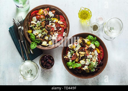 Traditionelle toskanische panzanella Italienischer Salat mit frischen Tomaten und Käse in Ton Platten und Weißwein in eine Flasche und Gläser. Authentische Mediterra Stockfoto