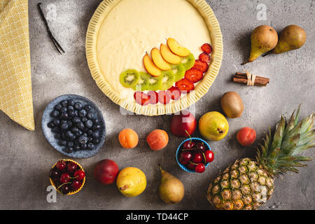 Obst Torte Torte Zubereitung mit frischen Teig und bunten Früchte bereit zu Backen. Stockfoto