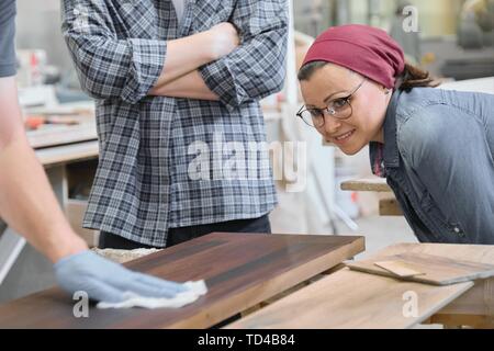 Holzbearbeitung Workshop, Arbeiter lackieren Holzregal Nahaufnahme. Stockfoto