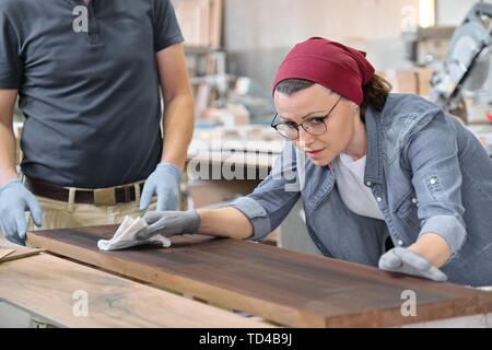 Reifen Handwerkerin in Woodshop. Weibliche Malerei Holzbrett mit Öl, Lack. Möbel Tischlerei Holz. Stockfoto