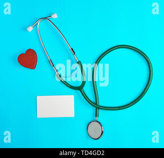 Medizinische Stethoskop und leeres Papier Visitenkarten auf einem blauen Hintergrund, Ansicht von oben Stockfoto