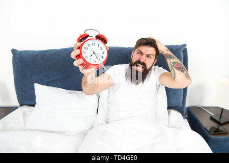 Beste Wecker für Menschen, die morgens hassen. Man bärtige Hipster hasse früh aufstehen. Zerstörerische Energie. Härteste Moment des Tages. Es ist völlig normal, den Alarm zu hassen. Hasserfüllt planen. Stockfoto