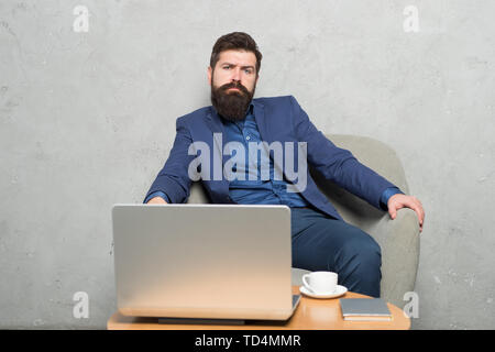 Moderne Geschäftsmann. Geschäftsmann Laptop. Mann trinken Kaffee im Büro. Reaktion auf geschäftliche E-Mails. Digitales Marketing. Im Internet surfen. Online kaufen. Projekt Manager. Geschäftliche Korrespondenz. Stockfoto