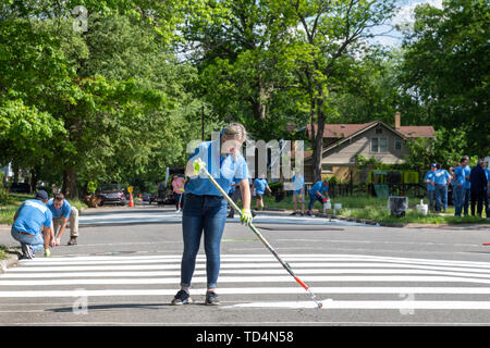 Detroit, Michigan - die Freiwilligen von Cooper Standard Hilfe ein neuer Stadtpark im Morningside Nachbarschaft bauen. Sie sind Malerei weißen Streifen auf dem Stockfoto