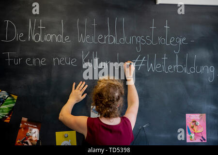 Berlin, Deutschland. 12 Juni, 2019. Vor einer Frau, die Nationale Weiterbildung Strategie der Bundesregierung, den Ländern, den Sozialpartnern und der Bundesagentur für Arbeit präsentiert, schreibt sie einen entsprechenden Text auf einer Tafel. Credit: Christoph Soeder/dpa/Alamy leben Nachrichten Stockfoto