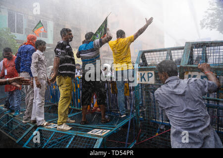 Kolkata, Indien. 12 Juni, 2019. Kolkata, Indien. 12 Juni, 2019. Bharatiya Janata Party (BJP) Anhänger durch die Polizei Barrikade inmitten Wasserwerfer während des Protestes in Kalkutta zu brechen versuchen. Bharatiya Janata Party workers Protest gegen die Tötungen von der BJP Arbeiter und auch auf die angebliche Verschlechterung der Lage im Bereich von Recht und Ordnung im Staat, die Polizei setzte Wasserwerfer und gas Tanks gegen die Demonstranten, die eine Rallye in Kolkata Polizeipräsidium statt. Credit: SOPA Images Limited/Alamy leben Nachrichten Stockfoto