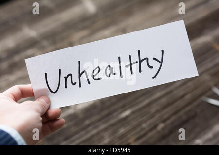 Hält Karte mit Text ungesund auf alten Holz Platte Stockfoto