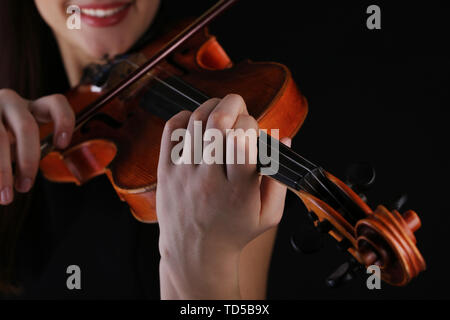 Musiker spielen Geige auf schwarzem Hintergrund Stockfoto