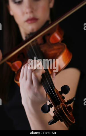 Musiker spielen Geige auf schwarzem Hintergrund Stockfoto